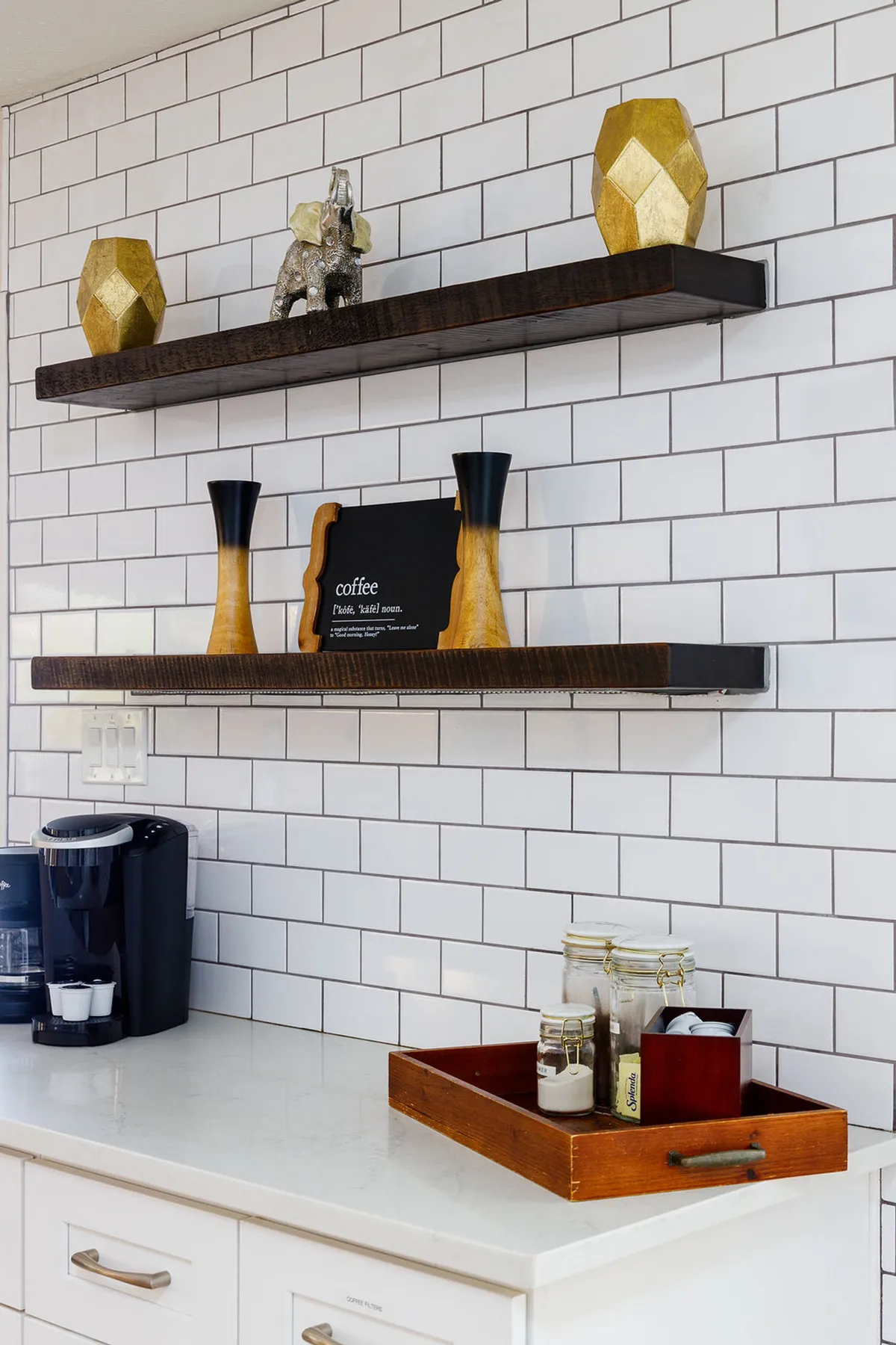 A cozy coffee bar nook with a coffee maker, decorative shelves, and a wooden tray with jars. The scene feels inviting, emphasizing morning rituals, sharing coffee, and the thoughtful amenities provided for guests.