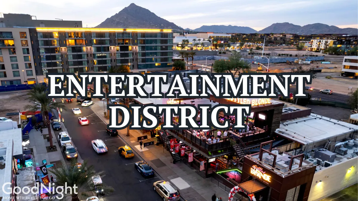 A lively nighttime streetscape in Scottsdale’s Entertainment District features illuminated signs, bustling entertainment venues, and people enjoying the vibrant nightlife. The mountain backdrop and energetic mood set the scene for evenings spent exploring restaurants, bars, and music venues.