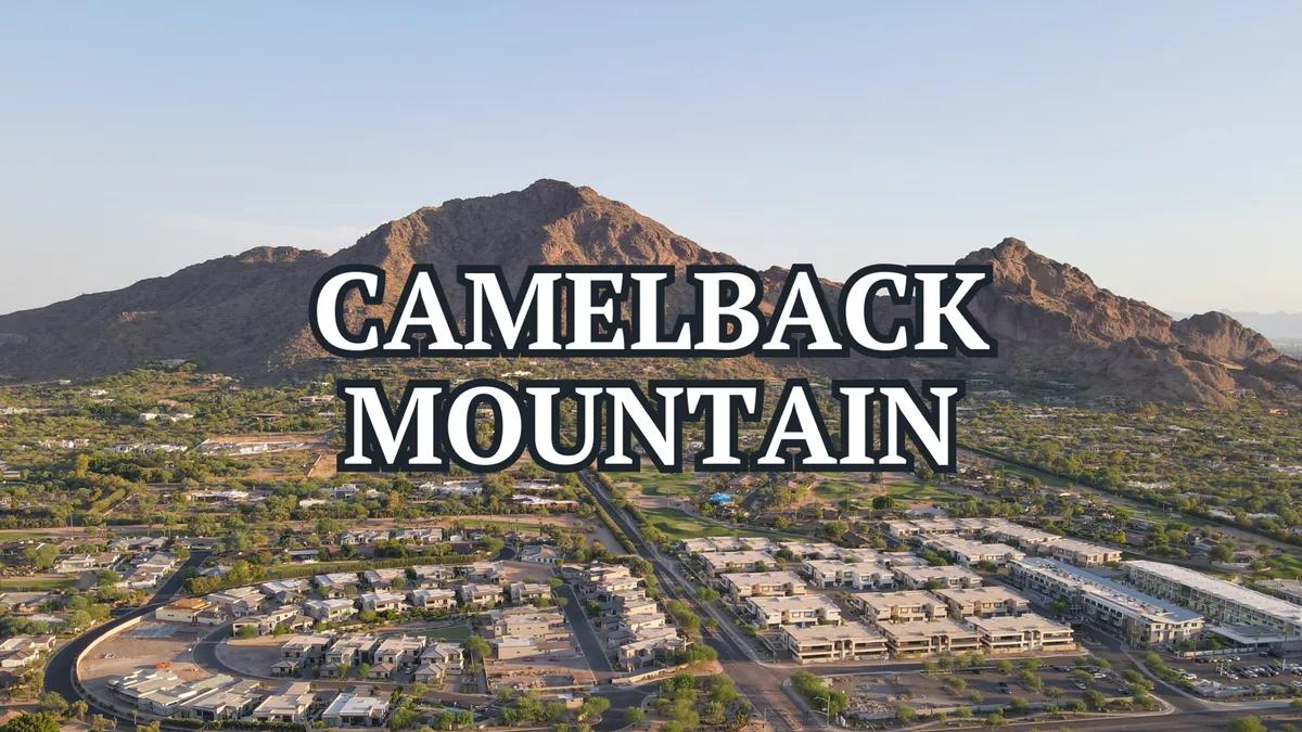 A panoramic view of Camelback Mountain rising above the surrounding residential area, bathed in tranquil sunset light. The iconic peak is visible in the distance, inviting outdoor exploration and adventure.